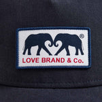 Navy Cotton Trucker Cap featuring a woven patch with LOVE BRAND & Co. elephant logo.