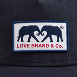 Navy Cotton Trucker Cap featuring a woven patch with LOVE BRAND & Co. elephant logo.