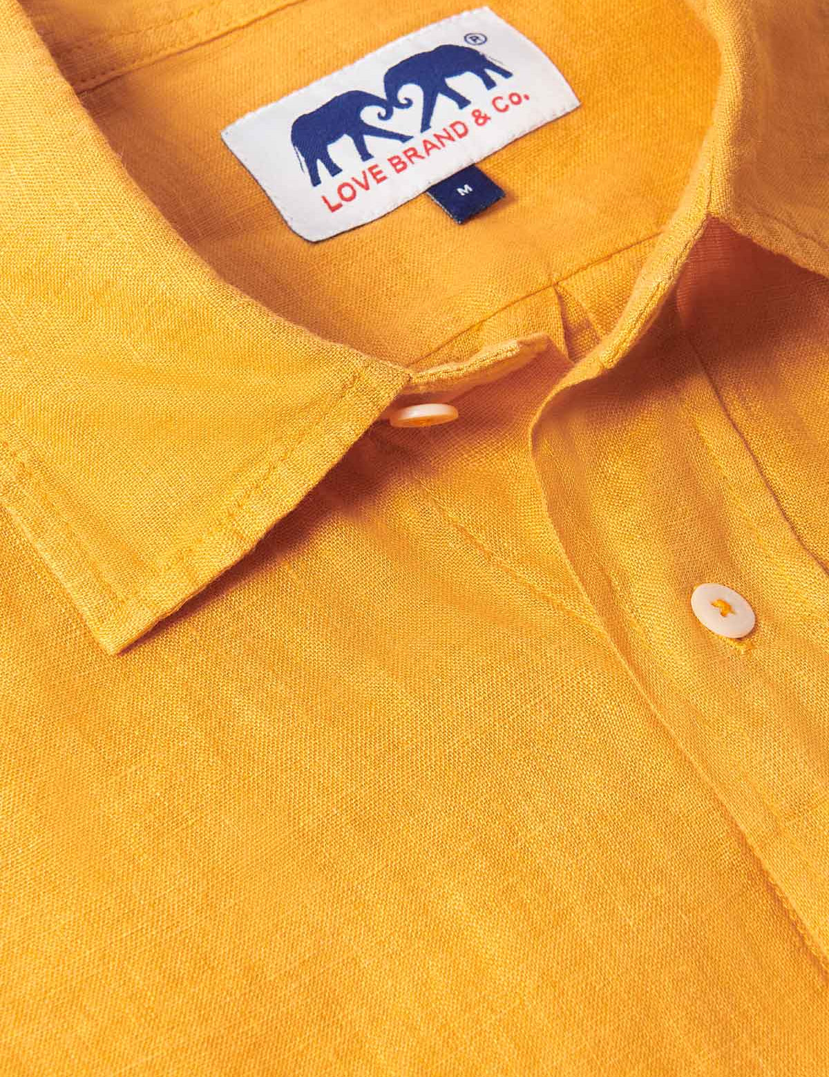 Close-up of our Golden Hour Abaco mens Linen Shirt showcasing its vibrant yellow colour and the brand label on the collar.. Old money shirts made from breathable linen fabric.