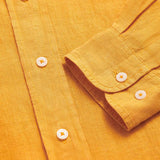 Close-up view of the Men's Golden Hour Abaco Linen Shirt showcasing the button details and linen texture in a warm golden color.