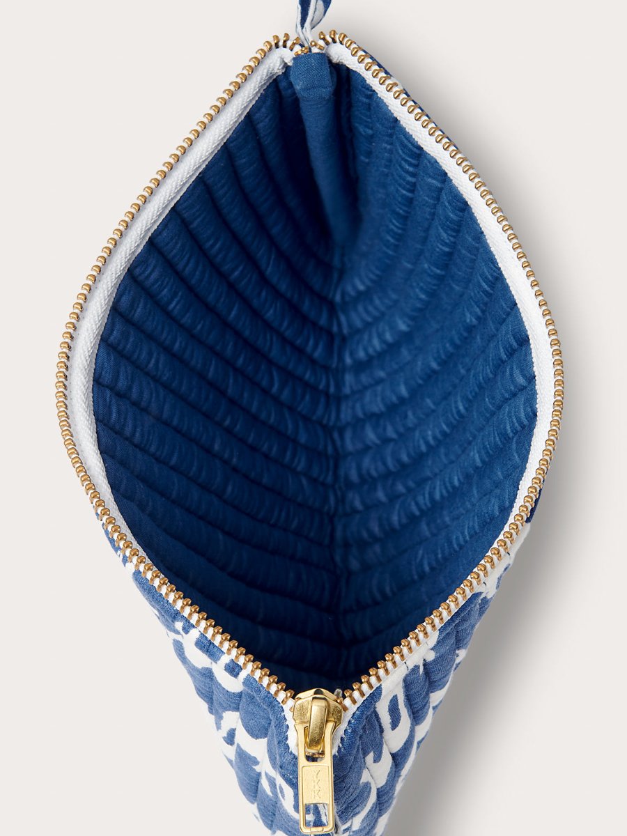 Quilted clutch bag with Elephant Palace Blue print, featuring a gold zipper and blue quilted interior.