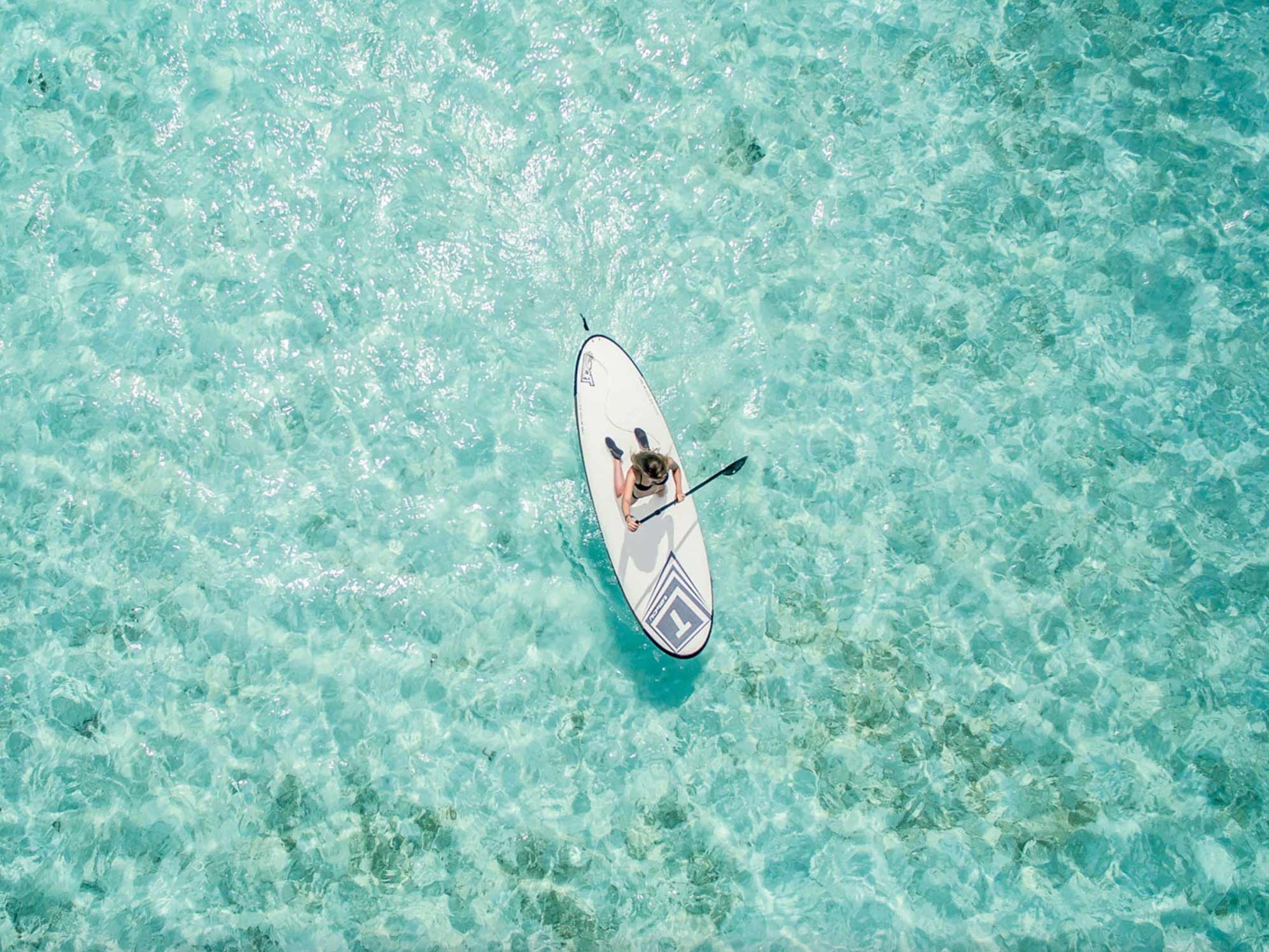 Woman paddle boarding on the waters surrounding the resort.