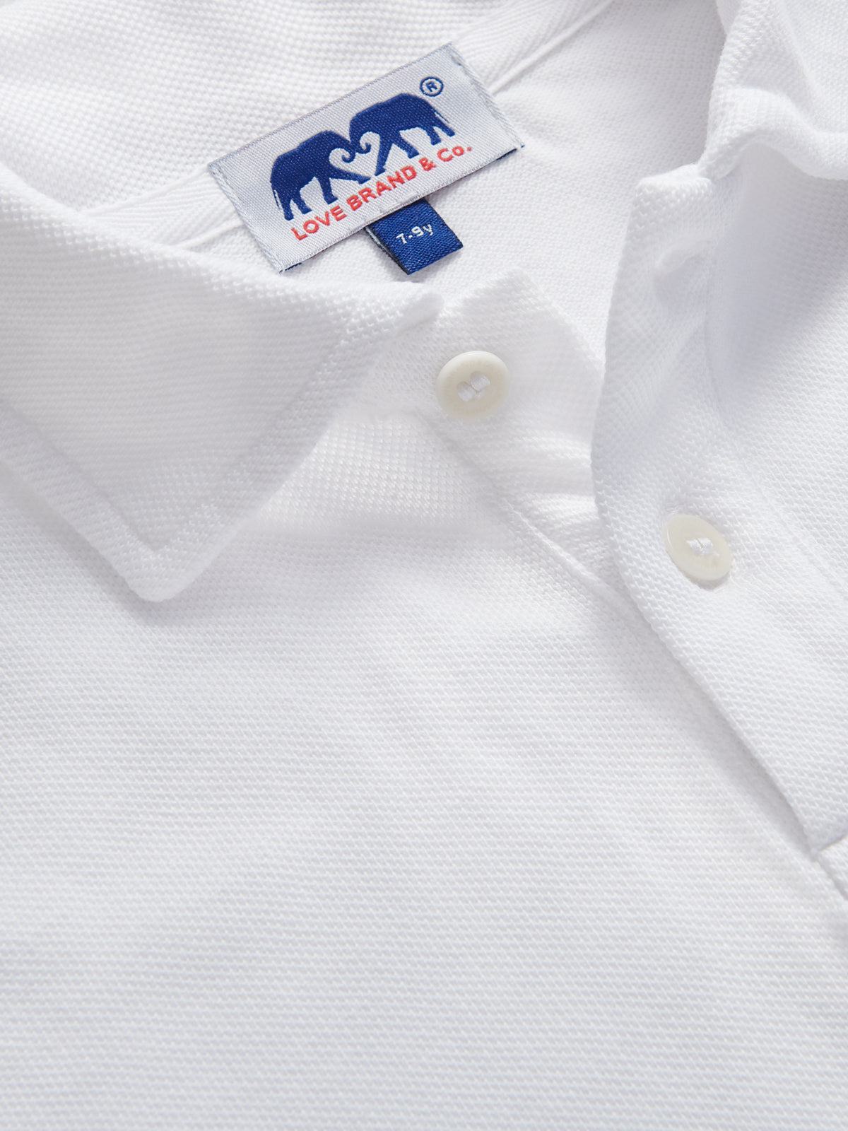 Detailed view of kids white polo shirt