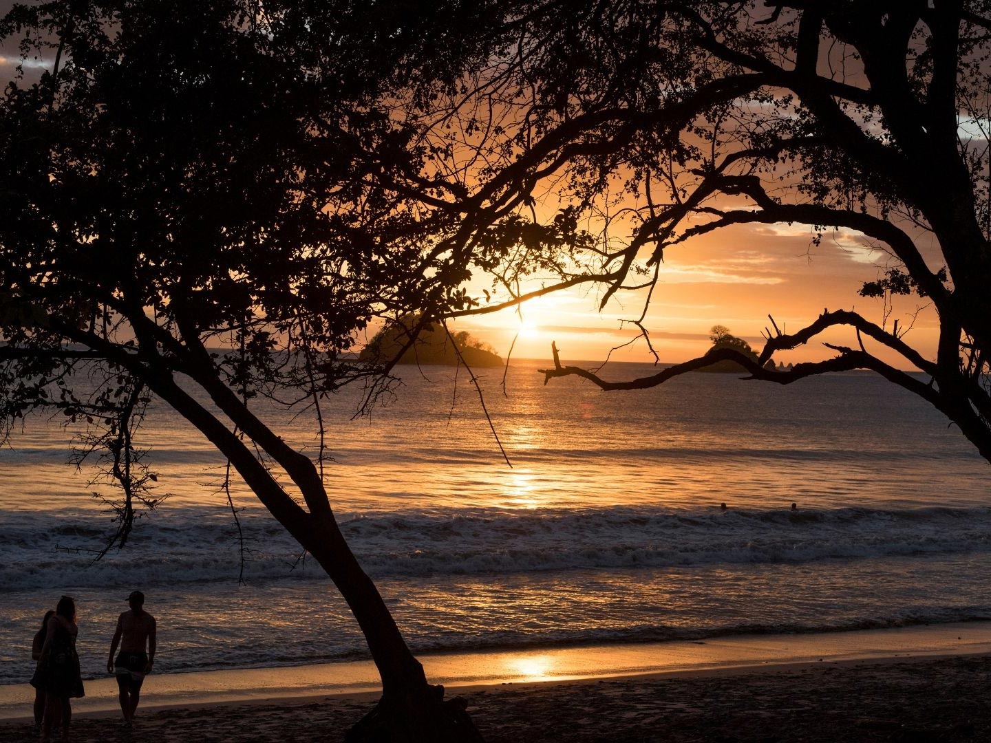 A family wander the Las Catalinas coastline at sunset