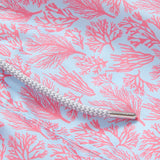 Close-up of Men's Crazy Coral Staniel Swim Shorts featuring a vibrant pink coral print on a light blue background, with a white drawstring.