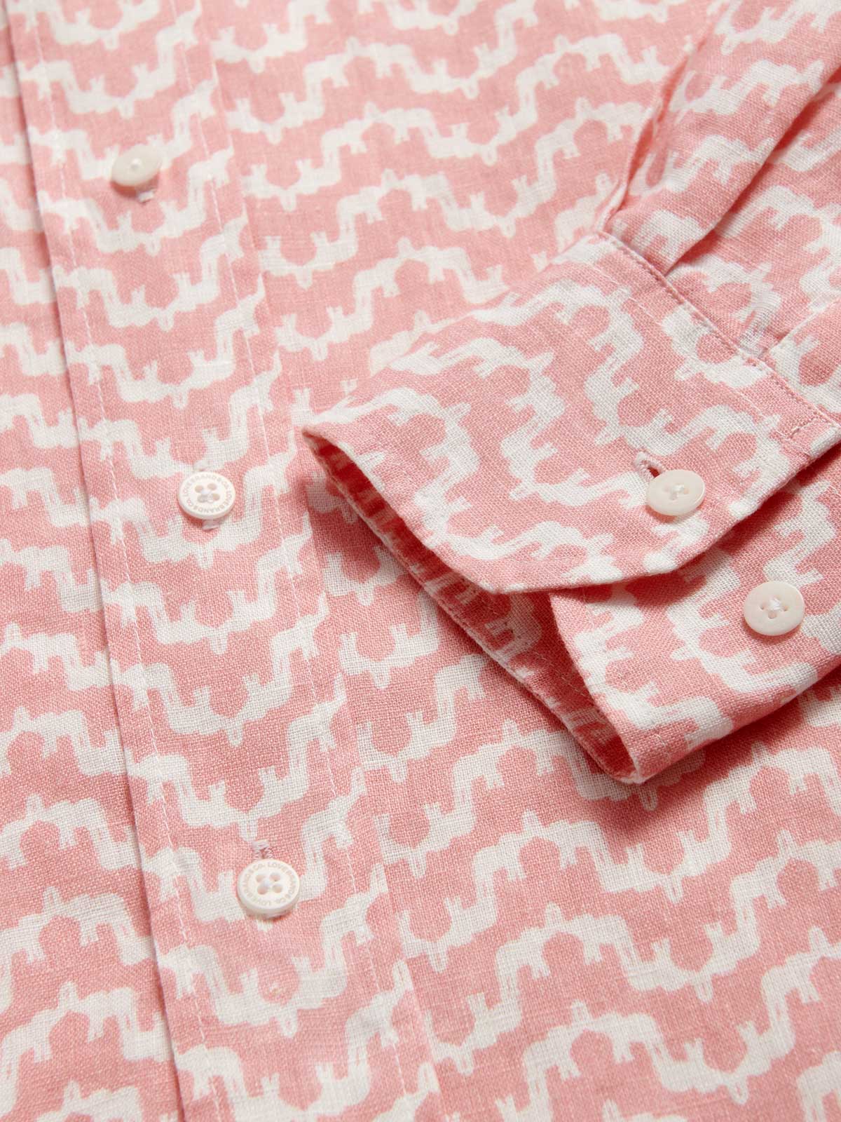 View of the cuff of Men's Elephant Palace Strawberry Abaco Linen Shirt. White and pink linen shirt featuring bestselling elephant palace print. Long-sleeved, button-up shirt in a relaxed fit.