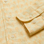 View of cuffs of Men's Palm Sundowner Abaco Linen Shirt by love brand & co. Yellow and orange patterned shirt with classic collar and long-sleeves. Button-up design made from 100% linen.