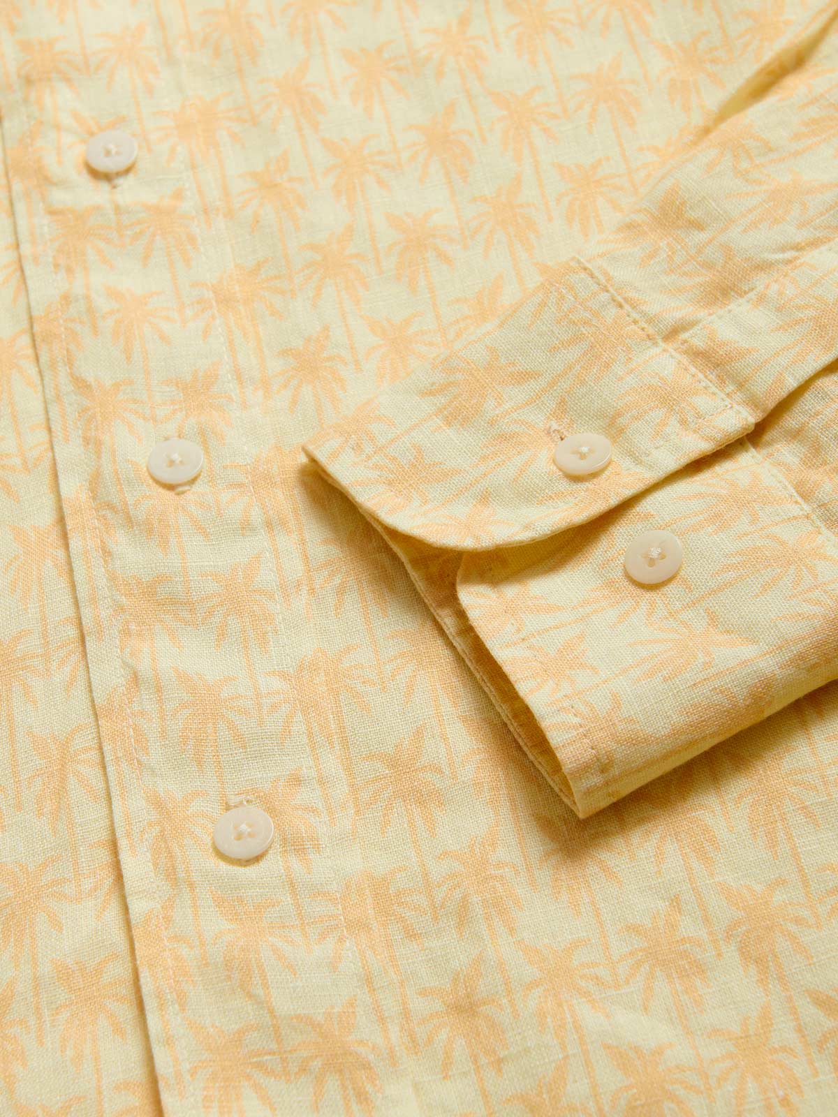 View of cuffs of Men's Palm Sundowner Abaco Linen Shirt by love brand & co. Yellow and orange patterned shirt with classic collar and long-sleeves. Button-up design made from 100% linen.