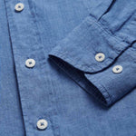 Close-up view of the collar of Men's Deep Blue Andros Linen Shirt. Denim blue linen shirt with double breasted pockets. Long-sleeved, button-up shirt.