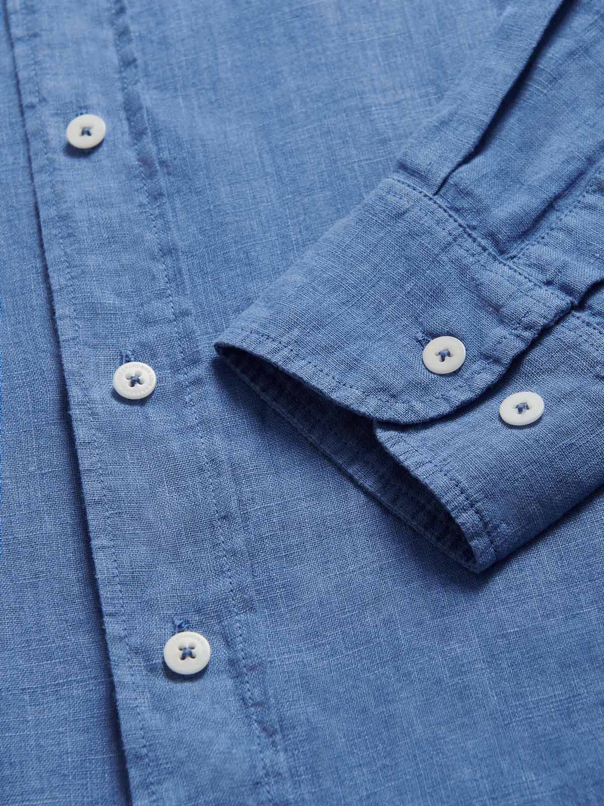 Close-up view of the collar of Men's Deep Blue Andros Linen Shirt. Denim blue linen shirt with double breasted pockets. Long-sleeved, button-up shirt.