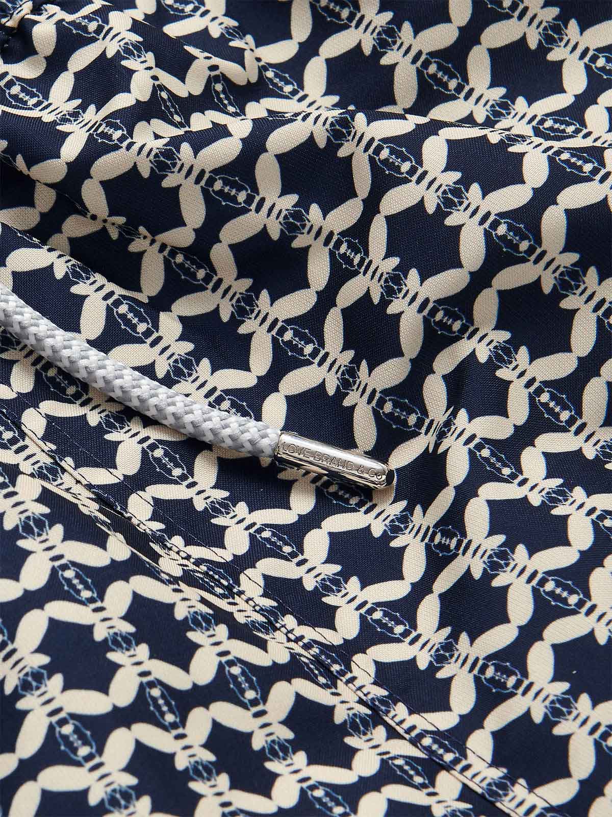 Close-up of the fabric detail on Men's Bee Propelled Staniel Swim Shorts with white bee patterns on a navy background and a grey drawstring.