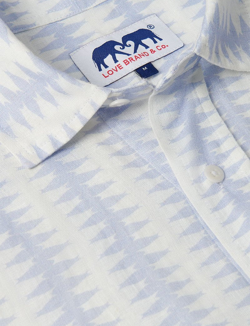 Close-up of Men's Dishy Fishy Abaco Linen Shirt featuring a chic print of a school of fish in serene blue and white hues.