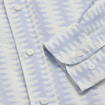 Close-up of Dishy Fishy Abaco men's Linen Shirt, featuring a serene blue and white fish pattern with white buttons, crafted from breathable 100% linen.