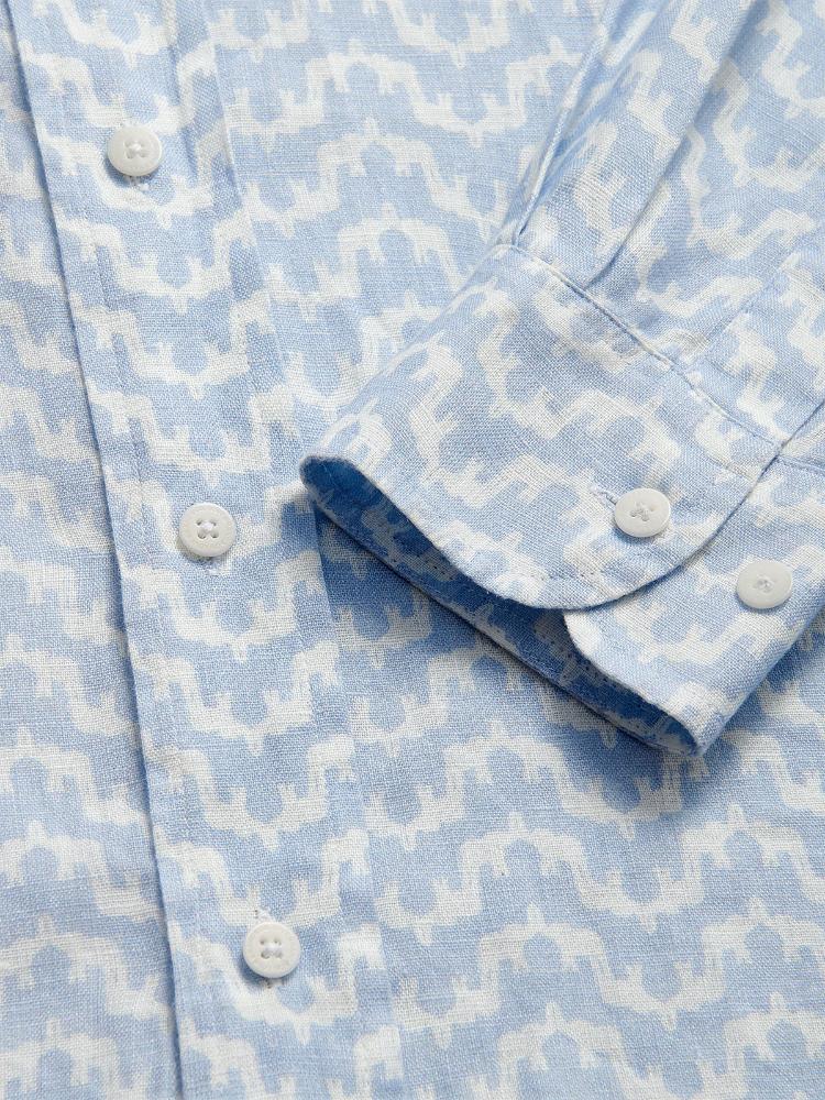 Close-up of Men's Elephant Palace Sky Abaco Linen Shirt in light blue with white elephant and palace print detailing.