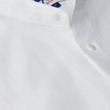 Men's White Go With The Flow Maycock Linen Shirt, featuring a close-up view of the breathable, lightweight linen fabric and a neatly stitched button.