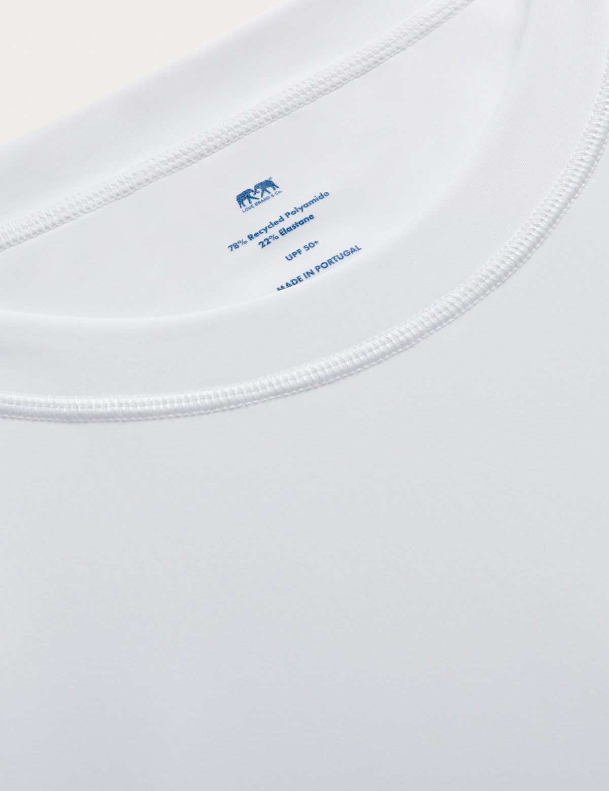 Close-up of mens white rash vest with classic rounded collar and long sleeves.