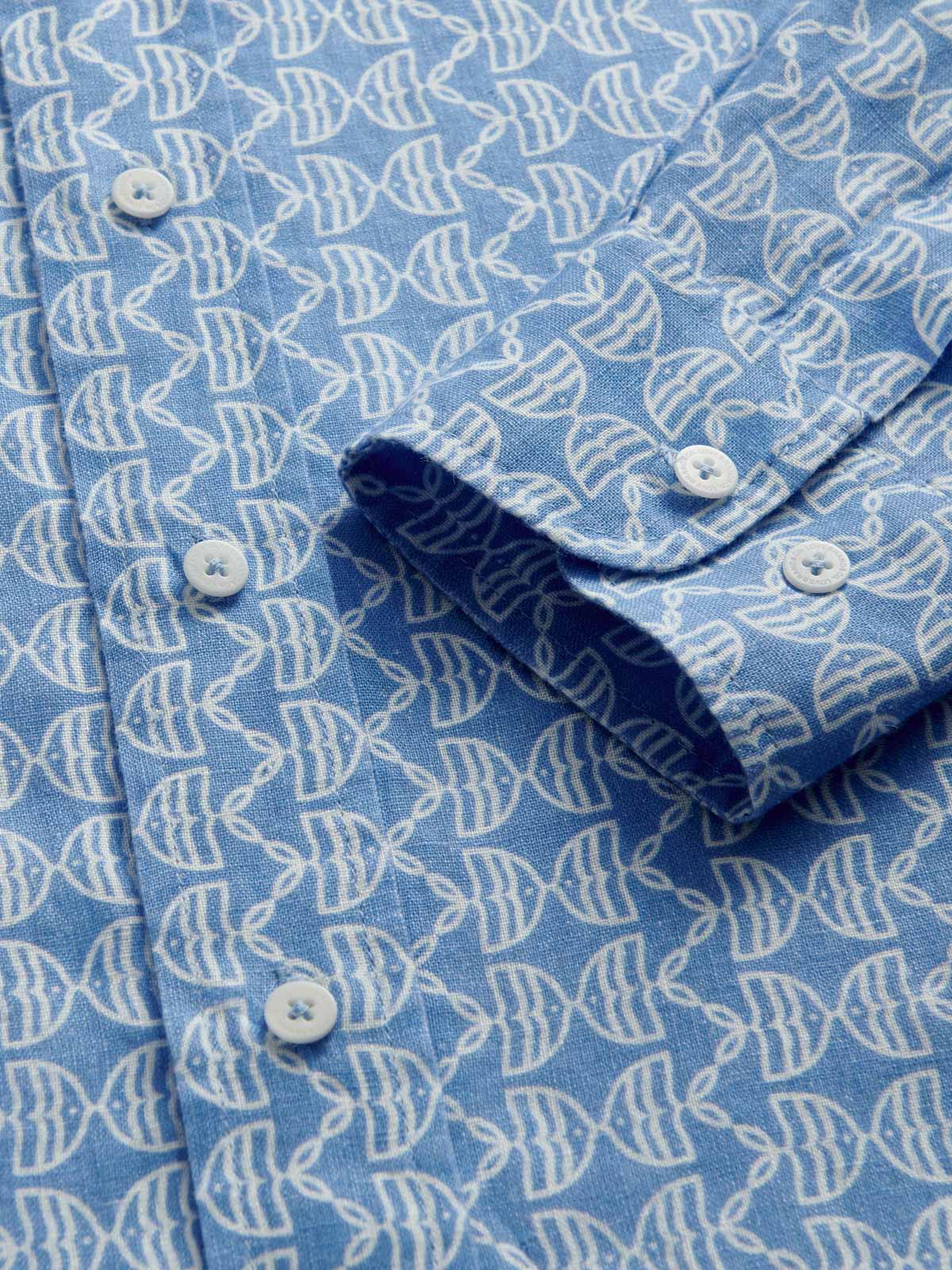 Close-up cuff view of Men's Kissing Fish Abaco Linen Shirt. Blue and white shirt with fish design.