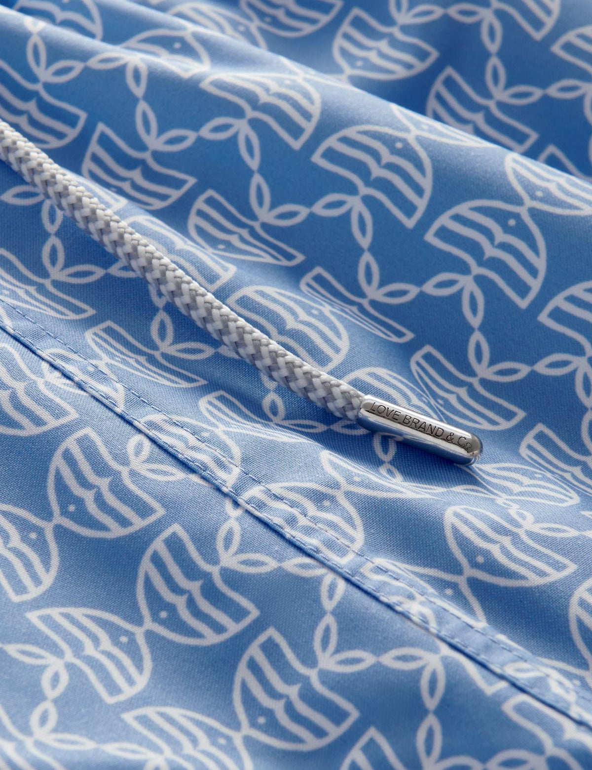 Detailed view of Men's Kissing Fish Staniel Swim Shorts showing white kissing fish on a blue base. 