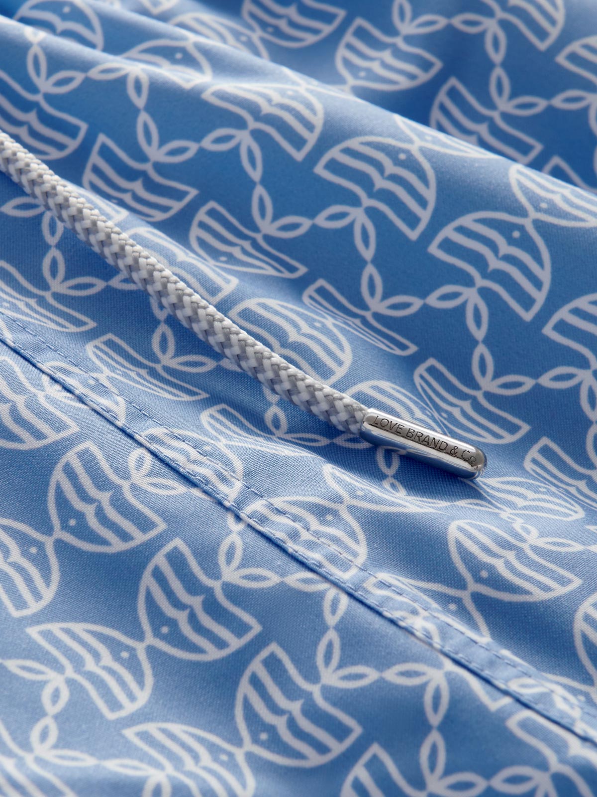 Detailed view of Men's Kissing Fish Staniel Swim Shorts showing white kissing fish on a blue base. 