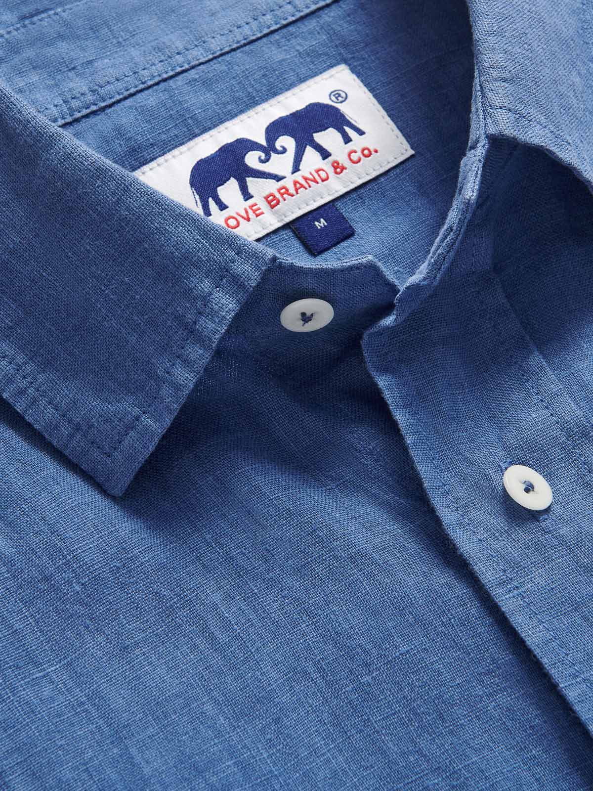 Detailed view of Men's Deep Blue Andros Linen Shirt. Denim blue linen shirt with double breasted pockets. Long-sleeved, button-up shirt.