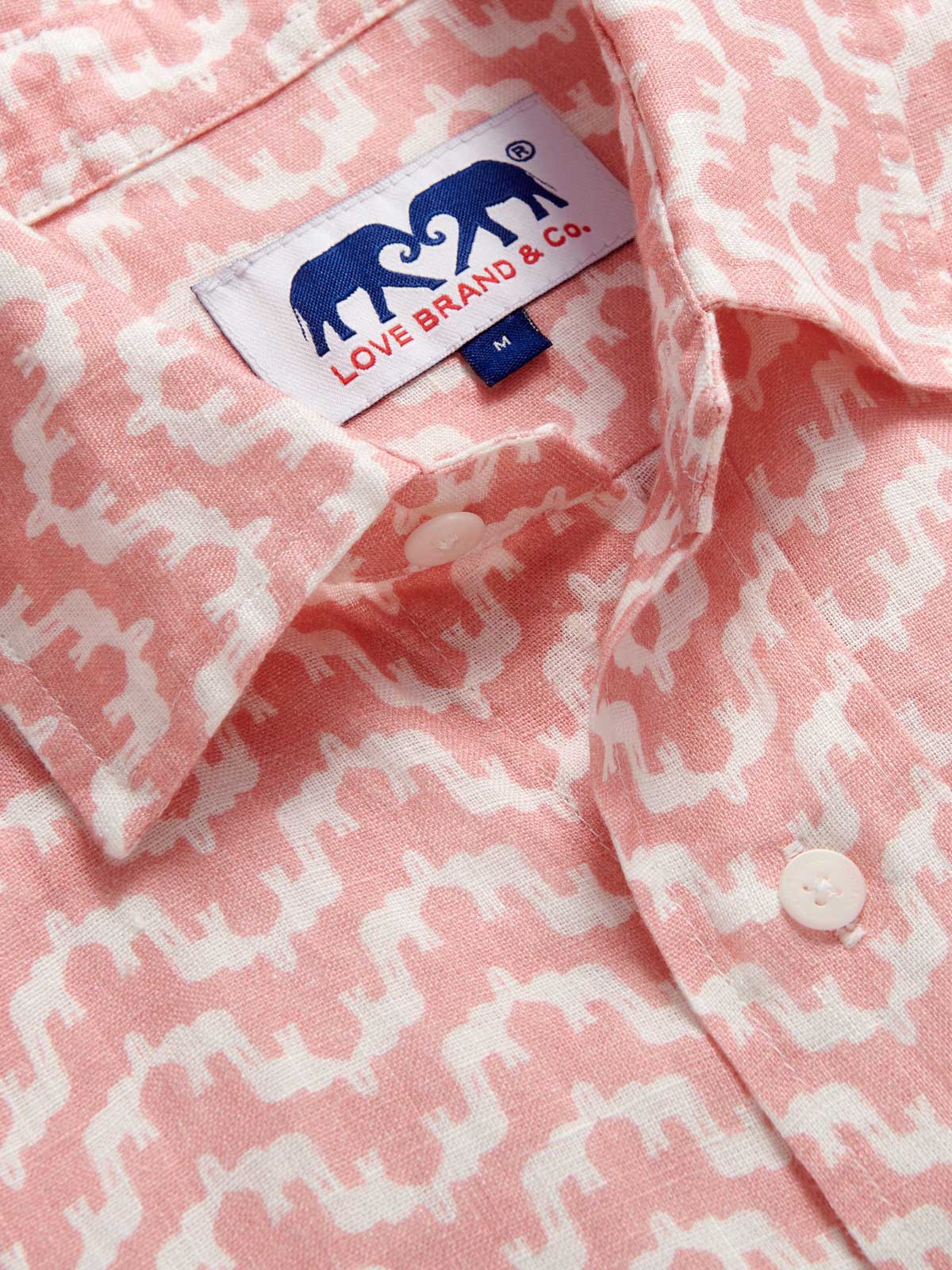 Close-up of Men's Elephant Palace Strawberry Abaco Linen Shirt. White and pink linen shirt featuring bestselling elephant palace print. Long-sleeved, button-up shirt in a relaxed fit.