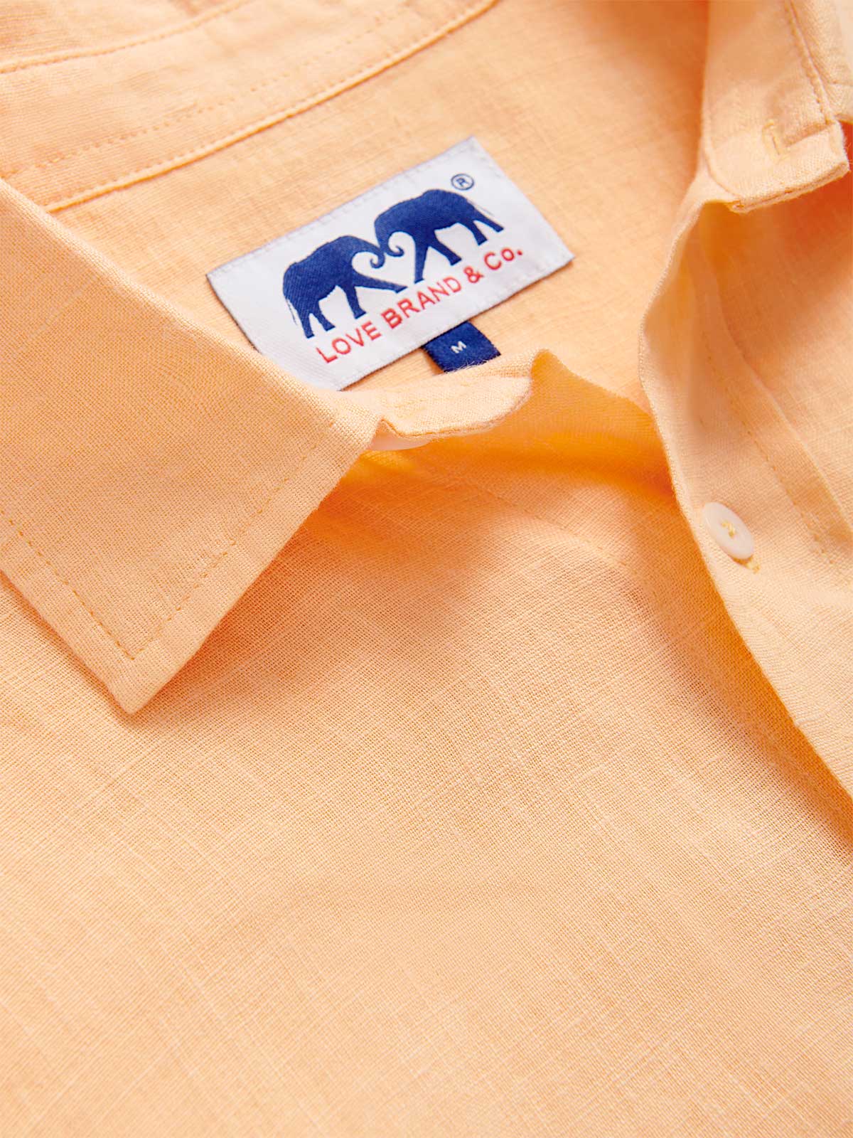 close-up view of the classic collar of Men's Orange Sorbet Abaco Linen Shirt. Long-sleeved button-up shirt made from 100% in orange. 