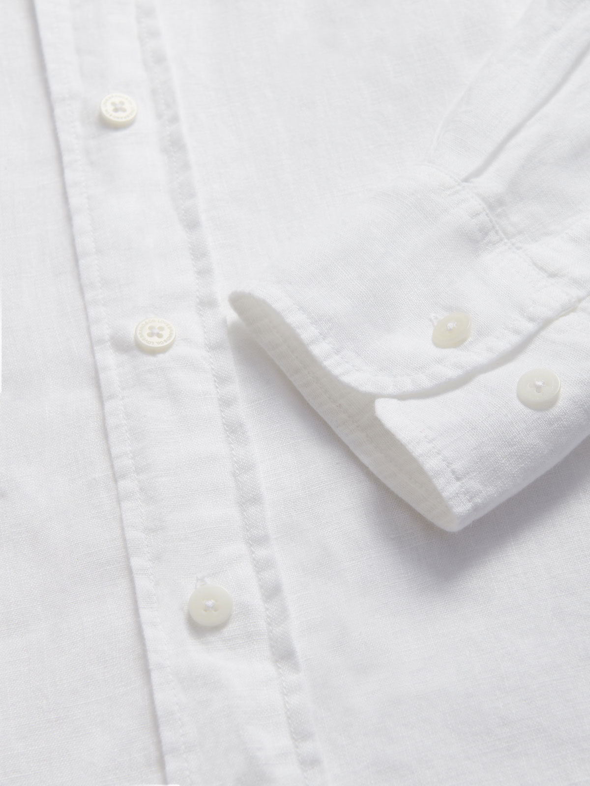 Close-up of Men's White Andros Linen Shirt cuffs. Long-sleeved, button-up white linen shirt. Double-breasted with a classic collar.