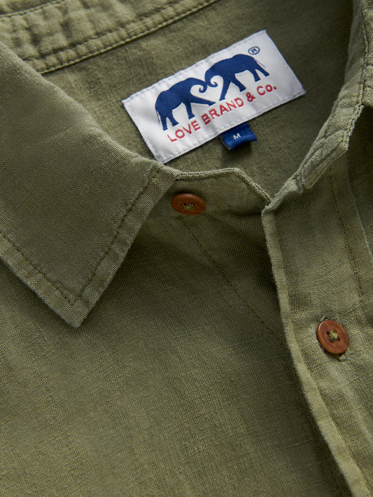 collar view of an olive green hemp shirt featuring love brand label of 2 elephants