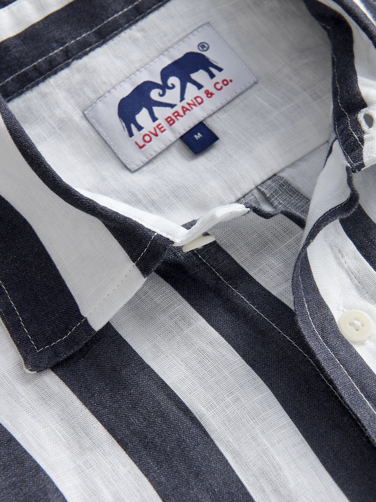Close-up of a striped shirt with a brand label on the collar.