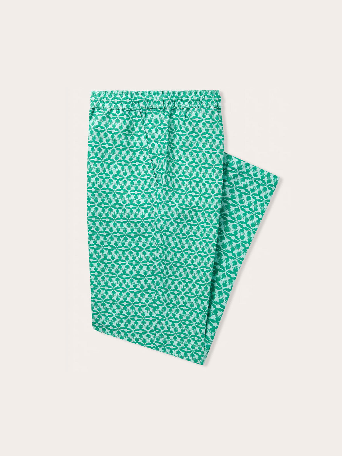 green linen trousers mens, featuring a pattern inspired by the Lesser Fish Eagle of India and tropical palms. mens linen trousers displayed on a light background.