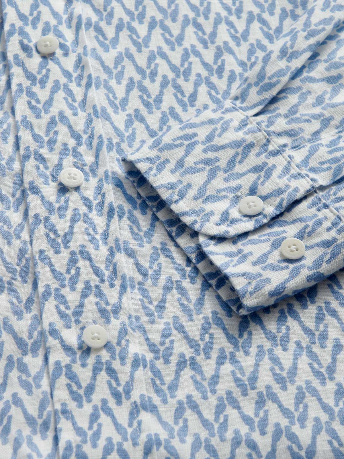 Close-up cuff view of Men's Parrot Paradise Abaco Linen Shirt. Blue and white mens linen shirt with a parrot pattern.