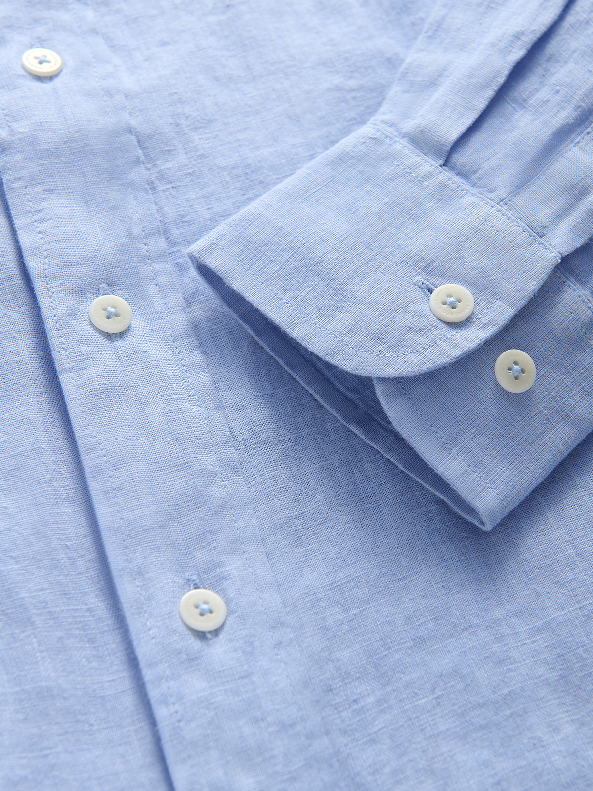 Close-up of a light blue linen shirt with buttons