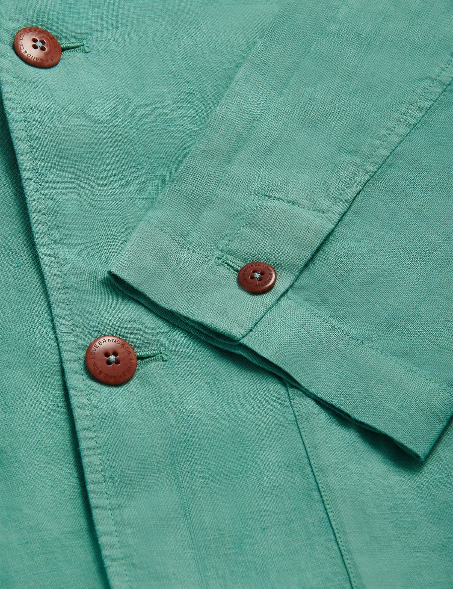 Close-up of Men's Riviera Green Nassau Linen Jacket with corozo nut buttons. Rich green fabric exuding old money style.