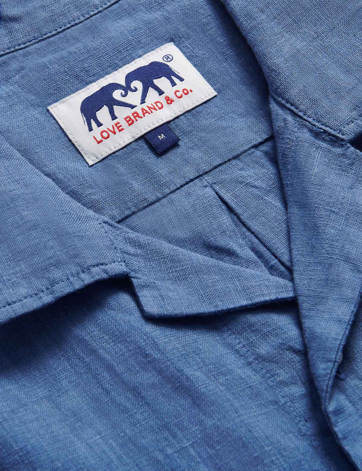 Close-up view of Men's Deep Blue Normans Linen Shirt. Blue short-sleeved linen shirt with 2 double breast pockets with a button-up design.