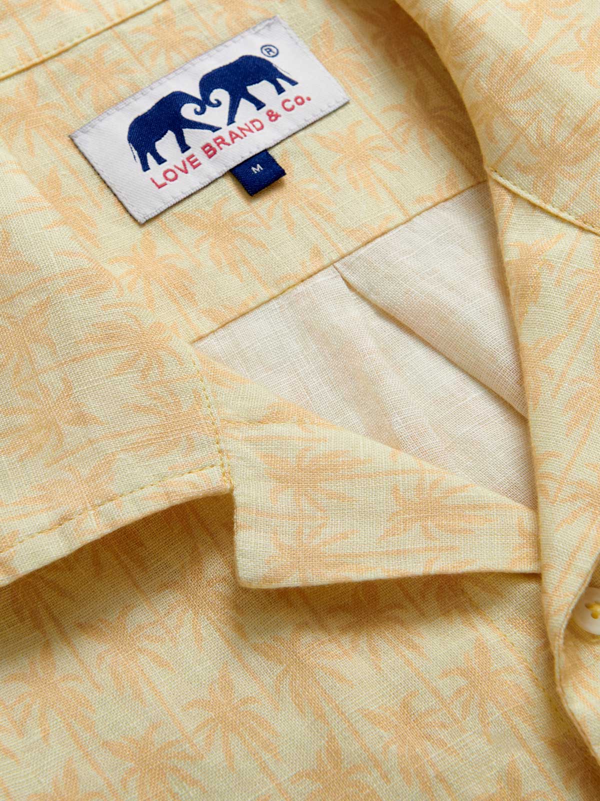 Close-up view of Men's Palm Sundowner Arawak Linen Shirt. Mens yellow printed shirt with front pocket, button-up design and camp collar.