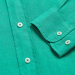 Men's Sicilian Green Abaco Linen Shirt with white buttons, close-up view showing fabric texture and sleeve detail, 100% linen material for comfort and breathability.