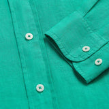 Men's Sicilian Green Abaco Linen Shirt with white buttons, close-up view showing fabric texture and sleeve detail, 100% linen material for comfort and breathability.