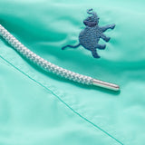 Close-up of Men's Elephants Galore Embroidered Staniel Swim Shorts in Cay Green featuring a Deep Blue embroidered elephant and a braided drawstring with a branded metal tip.