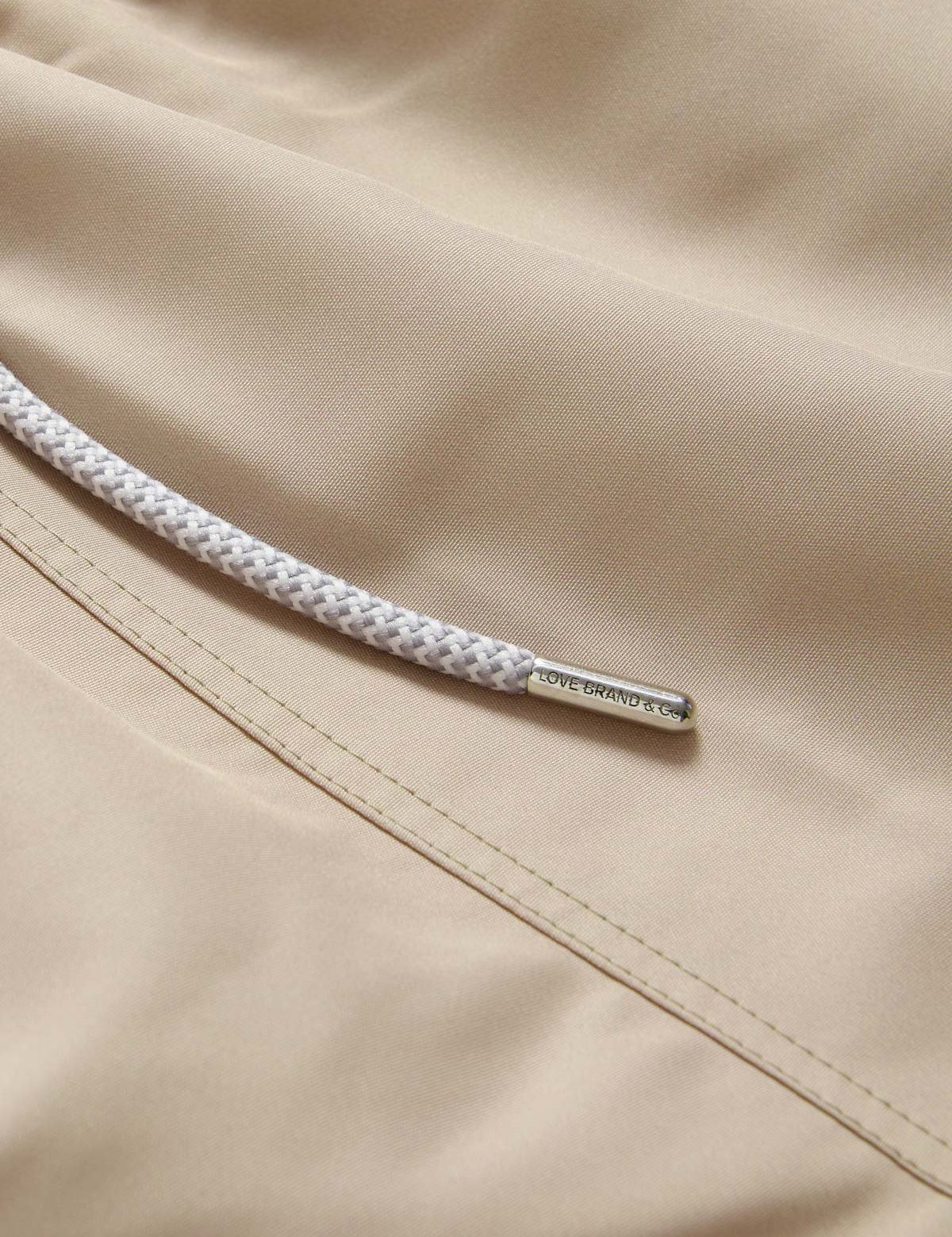 Close-up view of Men's Coconut Staniel Swim Shorts in beige colour by love brand & co. Brown swim shorts with pockets and drawstring waist.