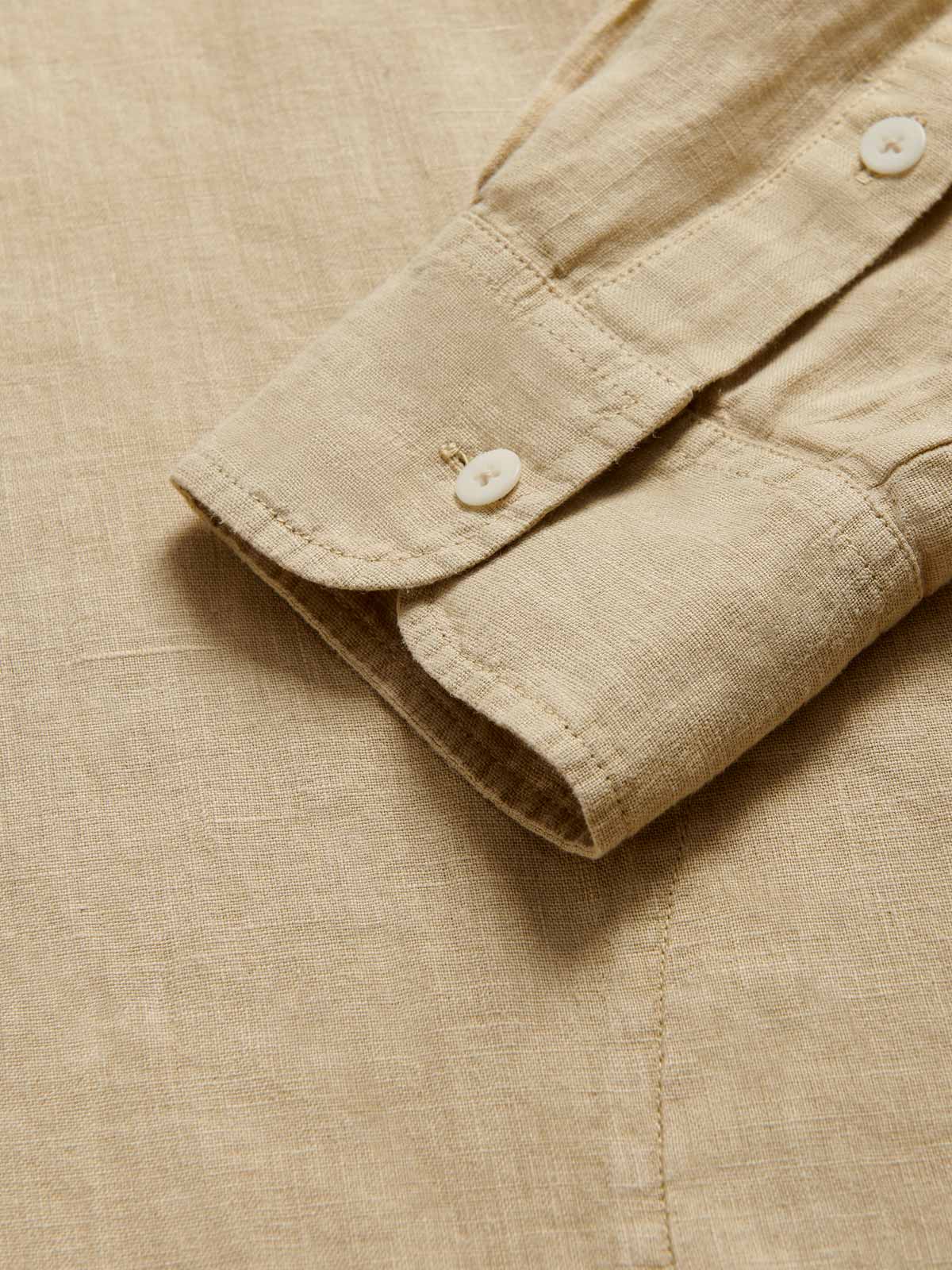 Detailed view of Men's Coconut Windermere Linen Long Sleeve Hoodie. Brown linen shirt with a drawstring hood. Crafted from 100% linen with half-button-up design and 2 large front pockets.