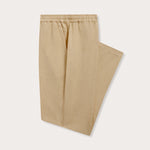 Side view of Men's Coconut Eleuthera Linen Trousers. Beige linen pants for men with 2 front pockets, drawstring tie and elastic waist in a relaxed fit.