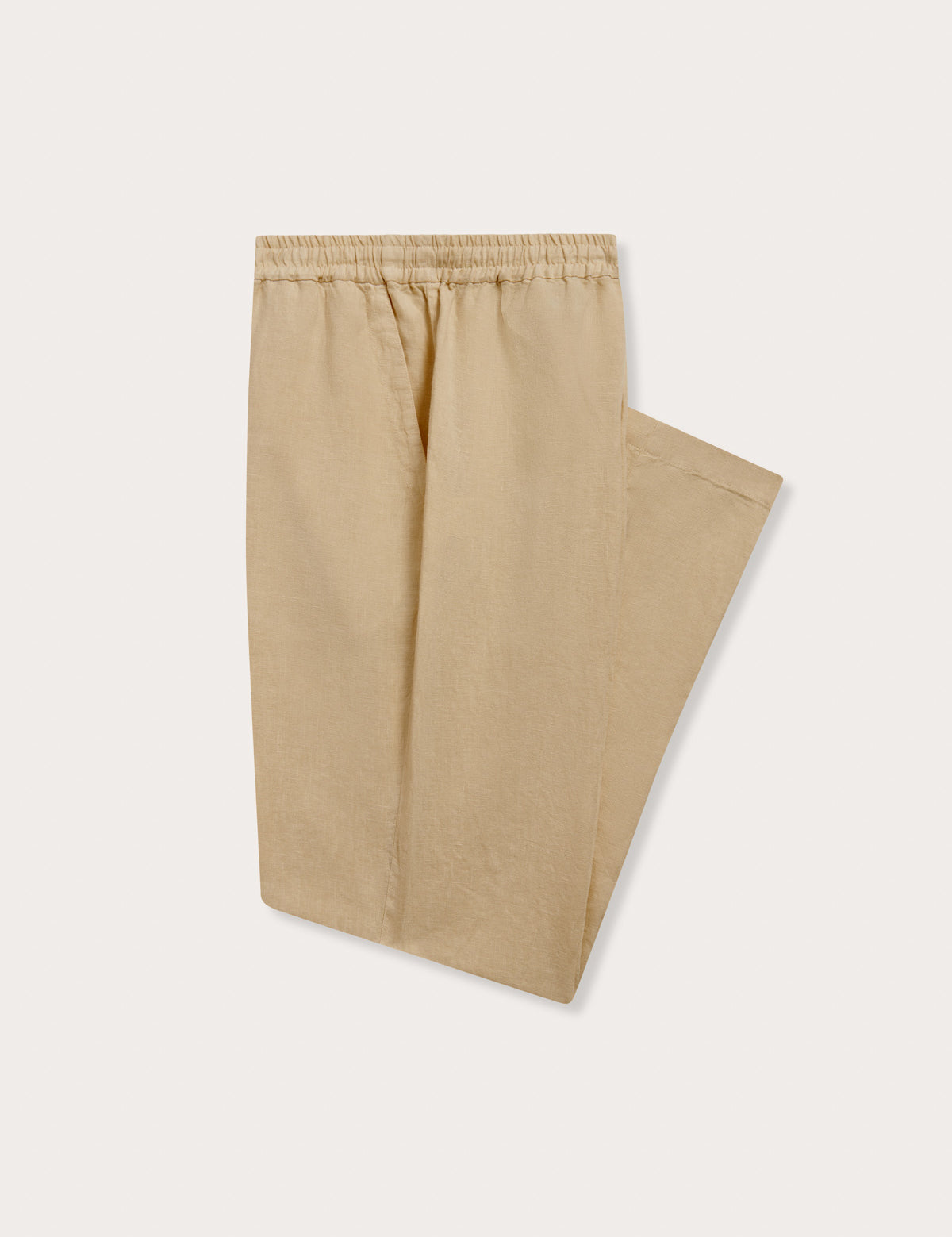 Side view of Men's Coconut Eleuthera Linen Trousers. Beige linen pants for men with 2 front pockets, drawstring tie and elastic waist in a relaxed fit.