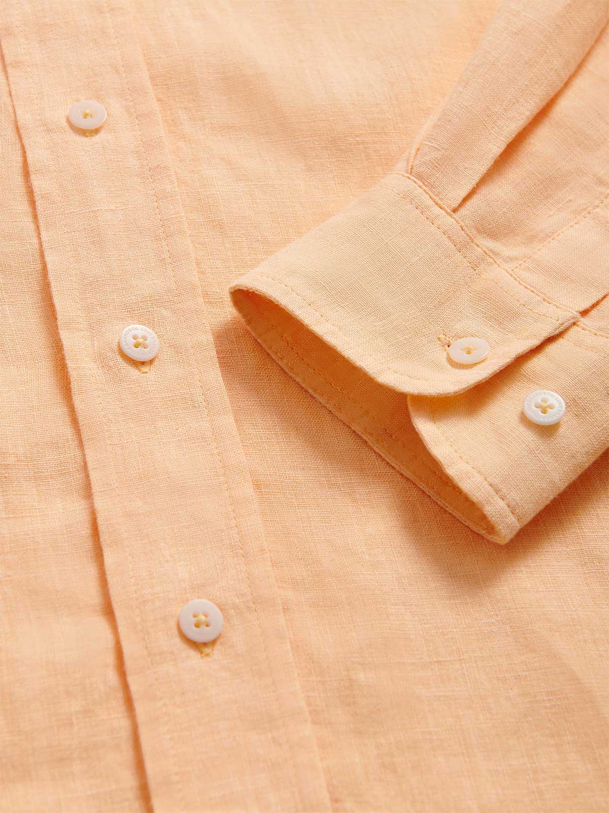 Detailed cuff view of Men's Orange Sorbet Abaco Linen Shirt. Long-sleeved button-up shirt made from 100% in orange. 