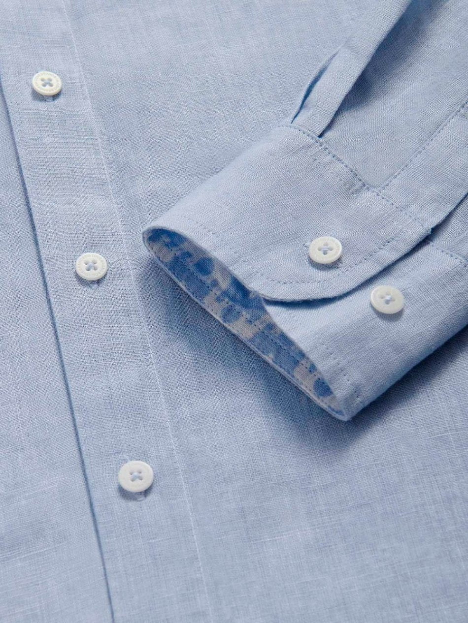 Men’s Elephant Palace Linen Shirt is a light blue men's linen shirt with white buttons and a folded cuff revealing an intricate Elephant Palace print in sky blue.