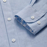 Men’s Elephant Palace Linen Shirt is a light blue men's linen shirt with white buttons and a folded cuff revealing an intricate Elephant Palace print in sky blue.