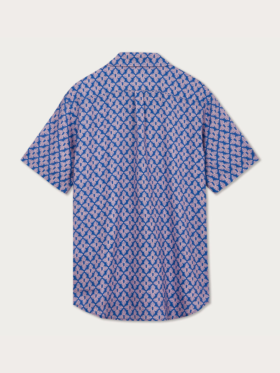 Men's Palm Paradise Arawak Linen Shirt in blue with pink Monstera leaf pattern. Men's linen shirt with short sleeves and sustainably made with 100% natural linen.