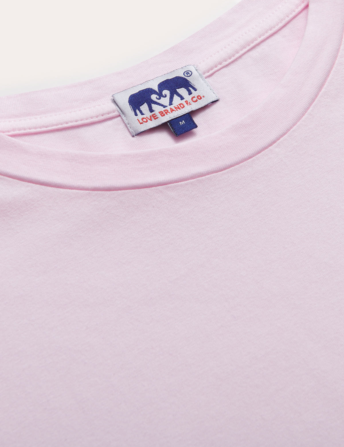 Close-up of Men's Pastel Pink Lockhart T-Shirt featuring soft, light power pink fabric and branded tag.