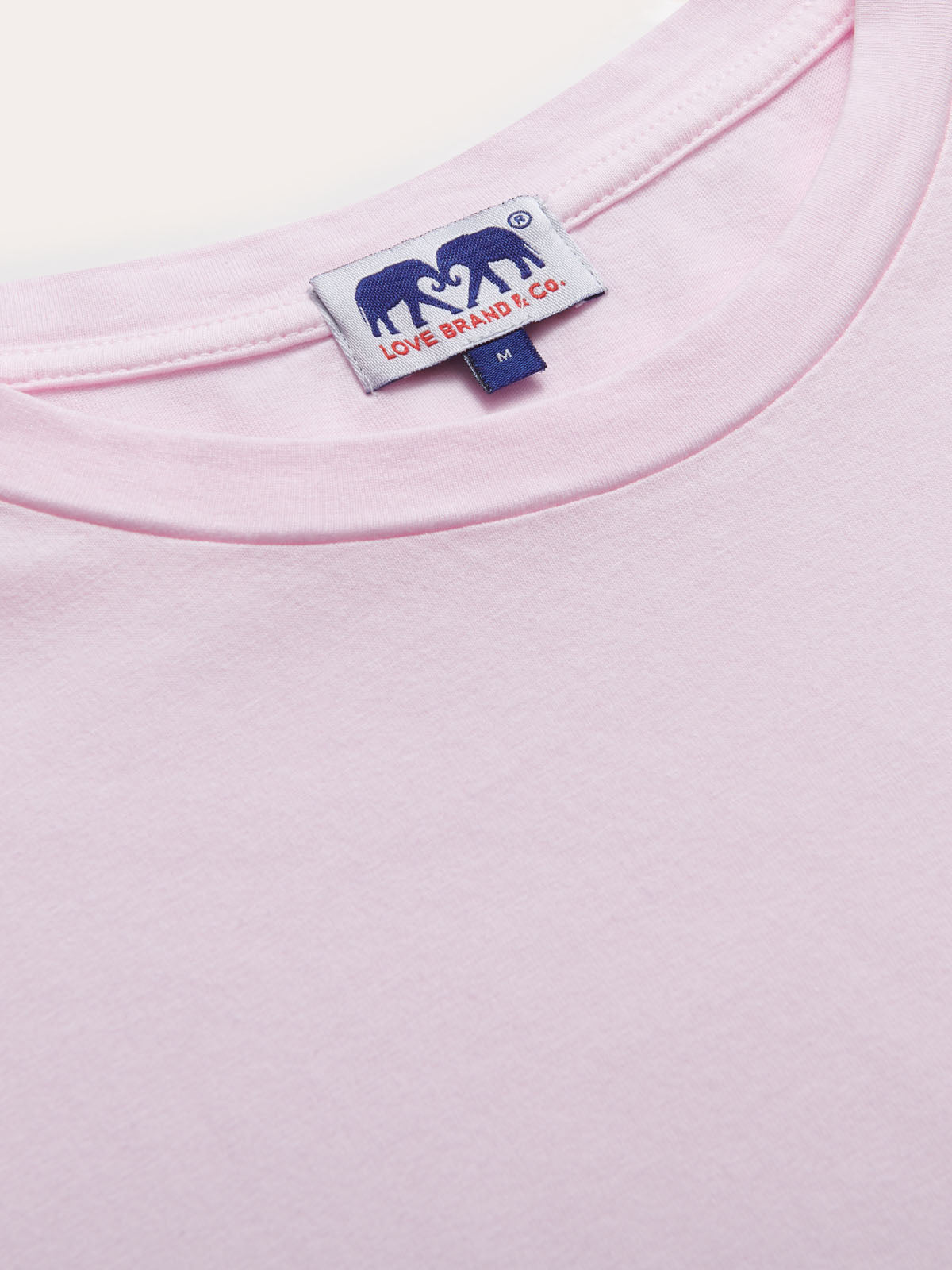 Close-up of Men's Pastel Pink Lockhart T-Shirt featuring soft, light power pink fabric and branded tag.