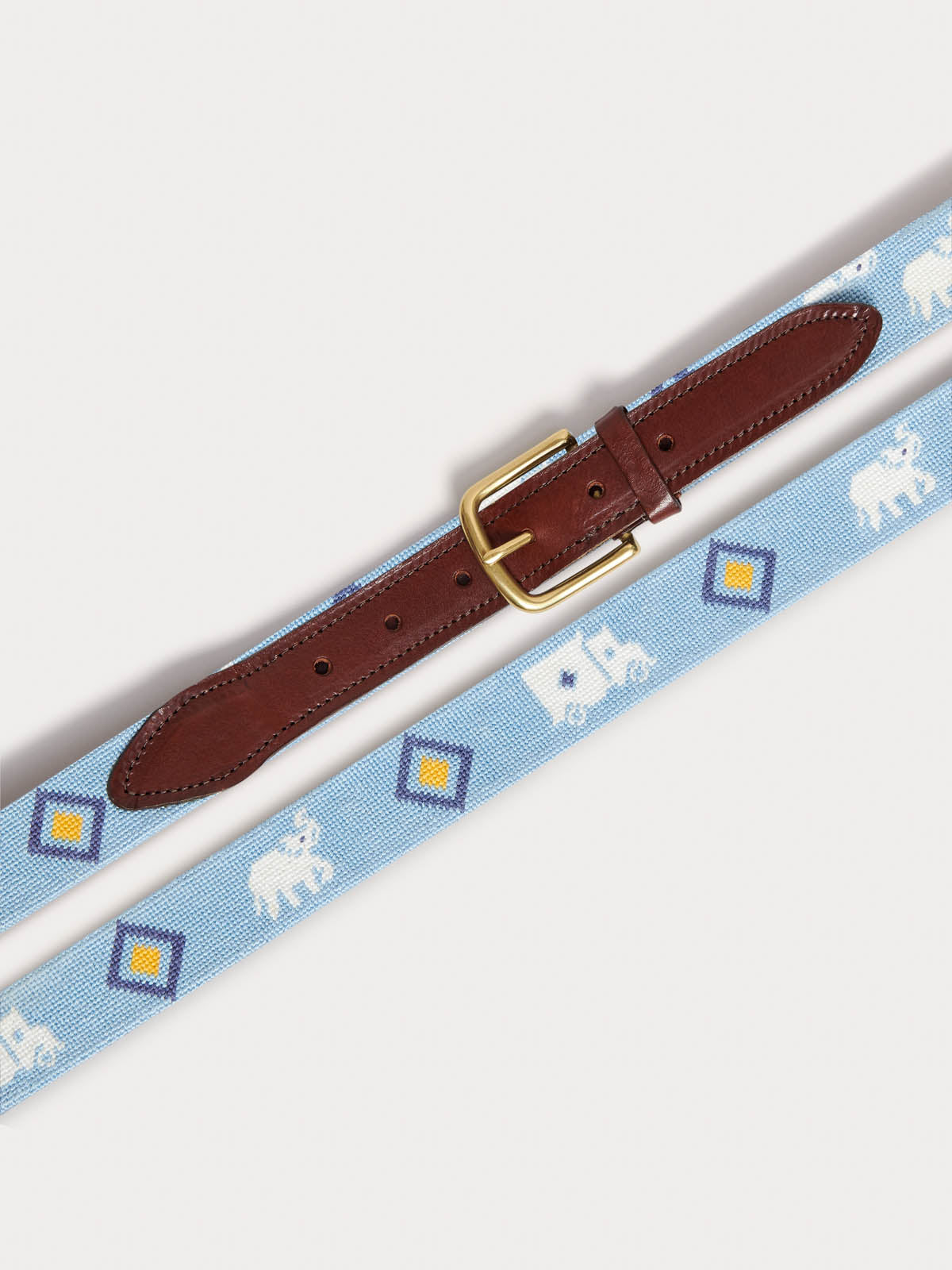 Needlepoint Belt - The G.E.M., featuring blue fabric with white Asian elephants and colorful Indian truck motifs, genuine leather strap, and solid brass buckle.