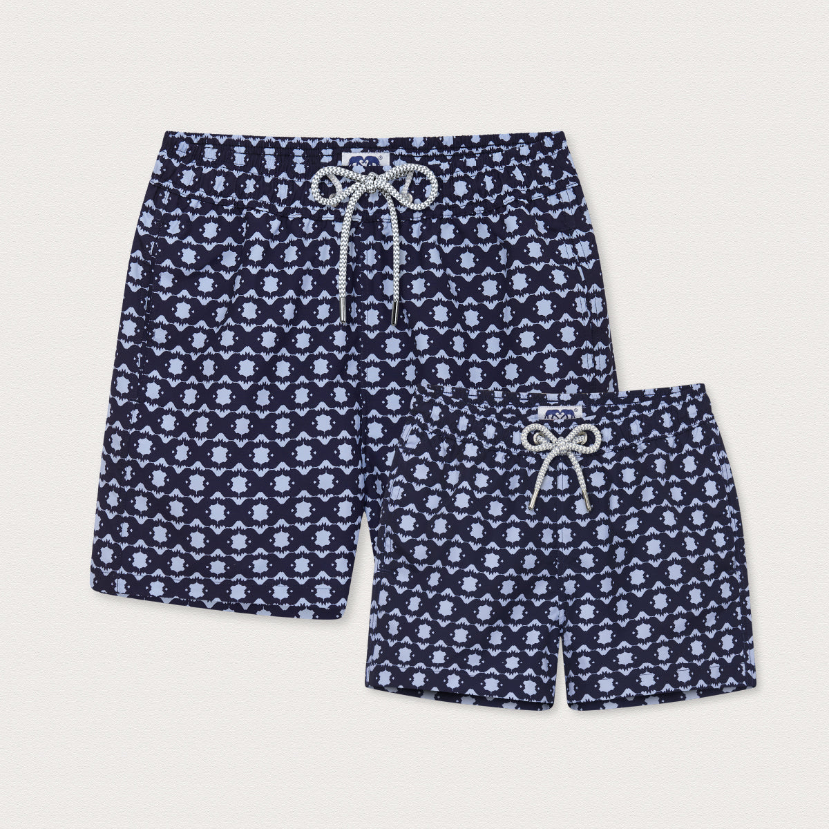 Two pairs of matching navy swim shorts with a geometric rhino pattern